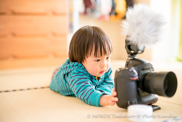 Nikonのカメラを楽しそうにいじる少年