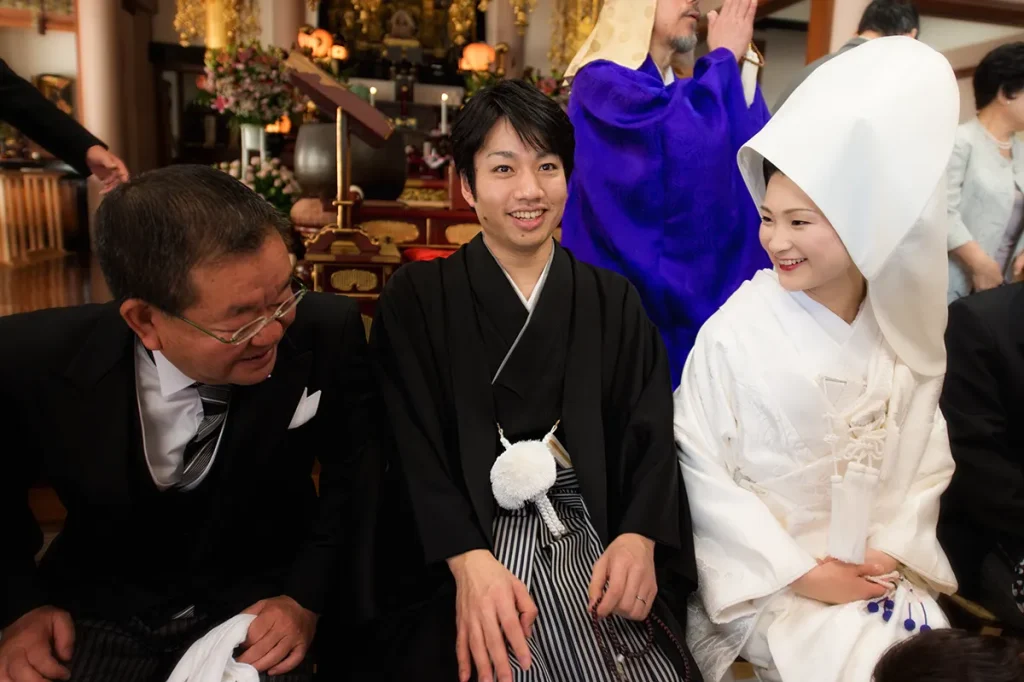 結婚式 挙式後の集合写真で、新郎お父さんがこれからよろしくお願いします。とご新婦様に話しかけている写真