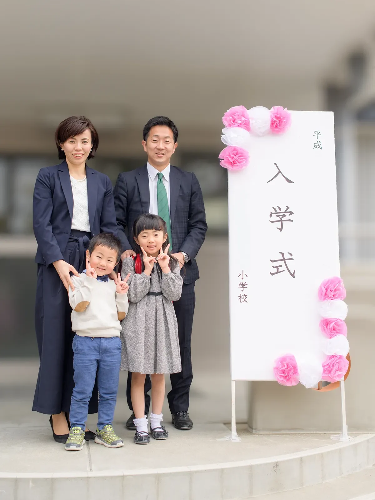 小学校の入学式 学校の看板の前で